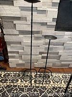 Both wrought iron candle holders side by side showing relative heights and bases