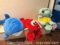 Blue whale, red lobster, Squirtle turtle plush toys on step