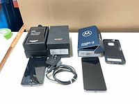 Two smartphones with boxes, charger, cable and case