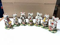 All seven ceramic pig band figurines front view
