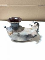 Left side view of raku vessel showing flared neck, rounded knobs and smoky glaze
