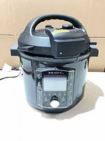 Front view of Instant Pot Pro showing handle, lid, digital control panel, and attached power cord