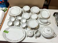 Entire set laid out on table showing plates, cups, bowls and serving pieces