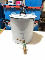 Front view showing pot, lid, side handles, and brass spigot