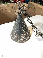Full view of punched tin pendant light showing shape, chain, finish