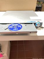 Front view of Samsung 5-disc changer with open disc tray and disc in place