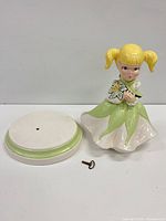 Figurine, base, and key side by side