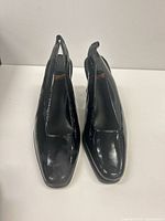 Front view of black patent slingback pumps