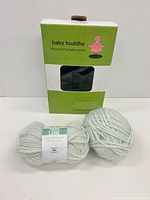 Front view of boxed Baby Buddha carrier with two yarn skeins