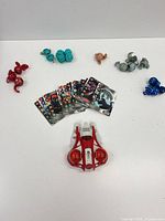 Full lot: figures arranged by colour, cards stack, red/white launcher