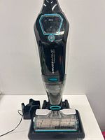 Front view of vacuum on charging base showing overall condition and accessories