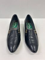 Top view of both pumps showing leather uppers, eyelet accents, insole label and overall condition