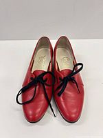 Front angled view of both red leather lace-up oxford shoes