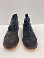 front view of both charcoal suede chukka boots showing uppers, laces, toe shape