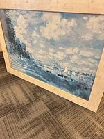 Overall view of framed Monet print leaning against floor