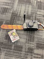 Chainsaw replica and boxed Funko Pop figure side by side for scale and contents overview