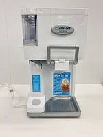 Front view of Cuisinart soft-serve ice cream maker showing brand badge, handle, drip tray, power cord
