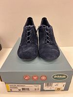 Front view of both shoes on box