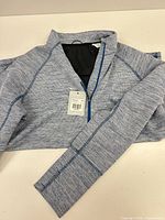 Pullover laid flat showing front and sleeve