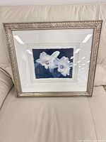 Front view of framed orchid print on sofa