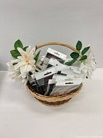 Basket containing multiple sealed H-E-R-S support kits with faux flowers on handle