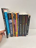 Front view of 12 paperbacks standing upright showing spines