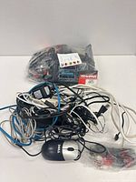 Pile of cables, Dell mouse in foreground, RC charger and connectors bag behind