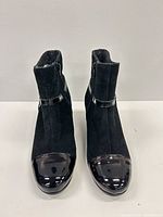 Front view of both ankle boots showing suede body, patent leather toe caps, overall style