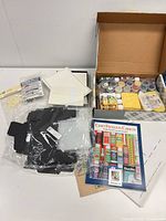Full lot overview showing paints, cards, embellishments, black cardboard pieces, catalog