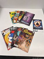 All nine comics laid out, front covers and one back cover visible