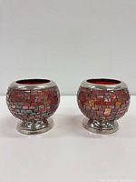 Front view of both red mosaic glass vases showing mosaic pattern and metal bases