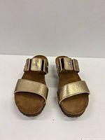 Front view of gold leather Naot slide sandals showing toe strap and buckle strap