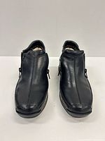 Front view of both black leather ankle boots showing zipper and toe condition