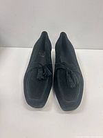 front view of black suede loafers with tassels