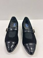 Front view of both shoes showing suede uppers, leather toe caps and buckle straps
