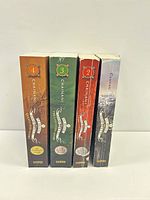 Spine view of all four volumes showing numbers 1-4 and publisher logo