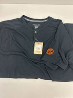 Full shirt laid flat showing color, sleeve logo and hang-tag