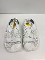 Top view of pair showing white and gray mesh upper, Velcro straps, yellow lining