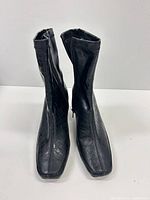 Front view of both boots showing square toes, croc texture, side zippers