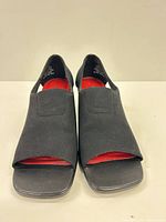 Front view showing black textile uppers, peep toes, red insoles