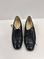 Front top view of both shoes showing patent toe caps, laces and snakeskin uppers
