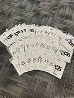 Group of sealed white dress shirts laid out showing quantity