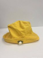 Front view yellow bucket hat with white rose accent