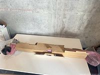 Roof rack components in cardboard and bubble wrap on table