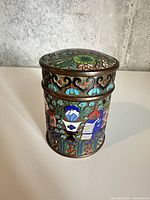 Overall view of cylindrical cloisonné enamel canister with lid in place