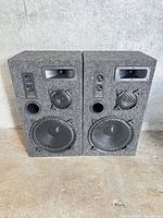 Front view of both Audio Digital 5000E speakers showing drivers, ports and overall condition