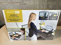 Front of sealed BirdRock Home bamboo sit-stand desk box displaying product images and labeling