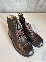 Three-quarter view of both boots showing uppers, laces, and cap toes