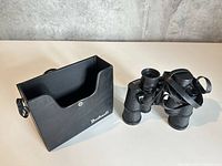 Binoculars next to open Bushnell case