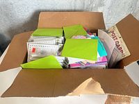 Open box showing large quantity of greeting cards and envelopes